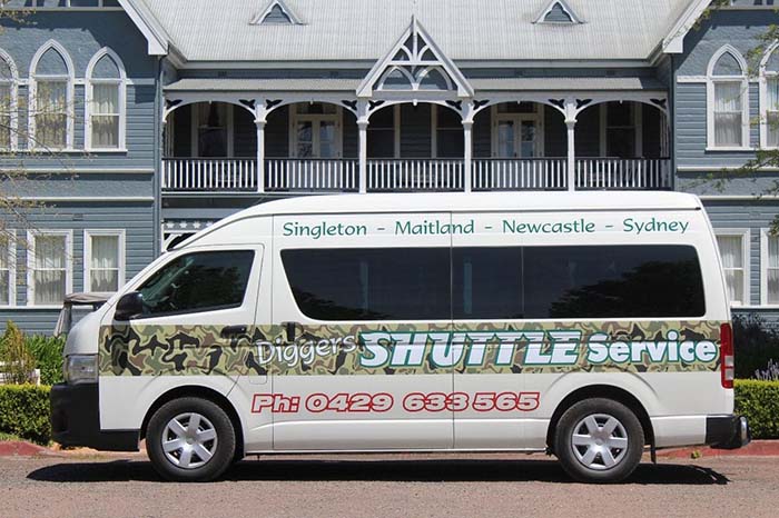 Diggers shuttle in front of period hotel
